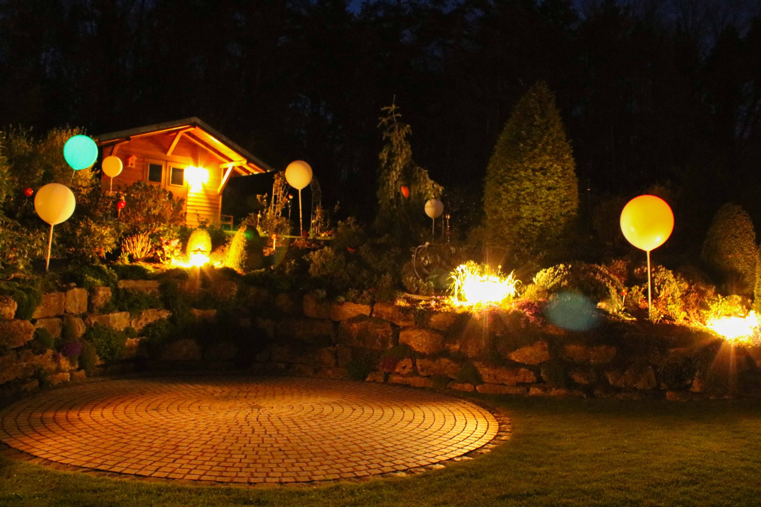 Stimmungsvoll beleuchteter Garten bei Nacht
