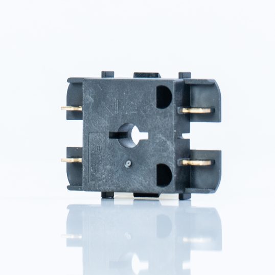 Spritzguss als Grundlage für hochwertige Hybridbauteile, Smybolbild. Schwarzes Kunststoffteil mit Metall-Einlage auf weißem Untergrund.